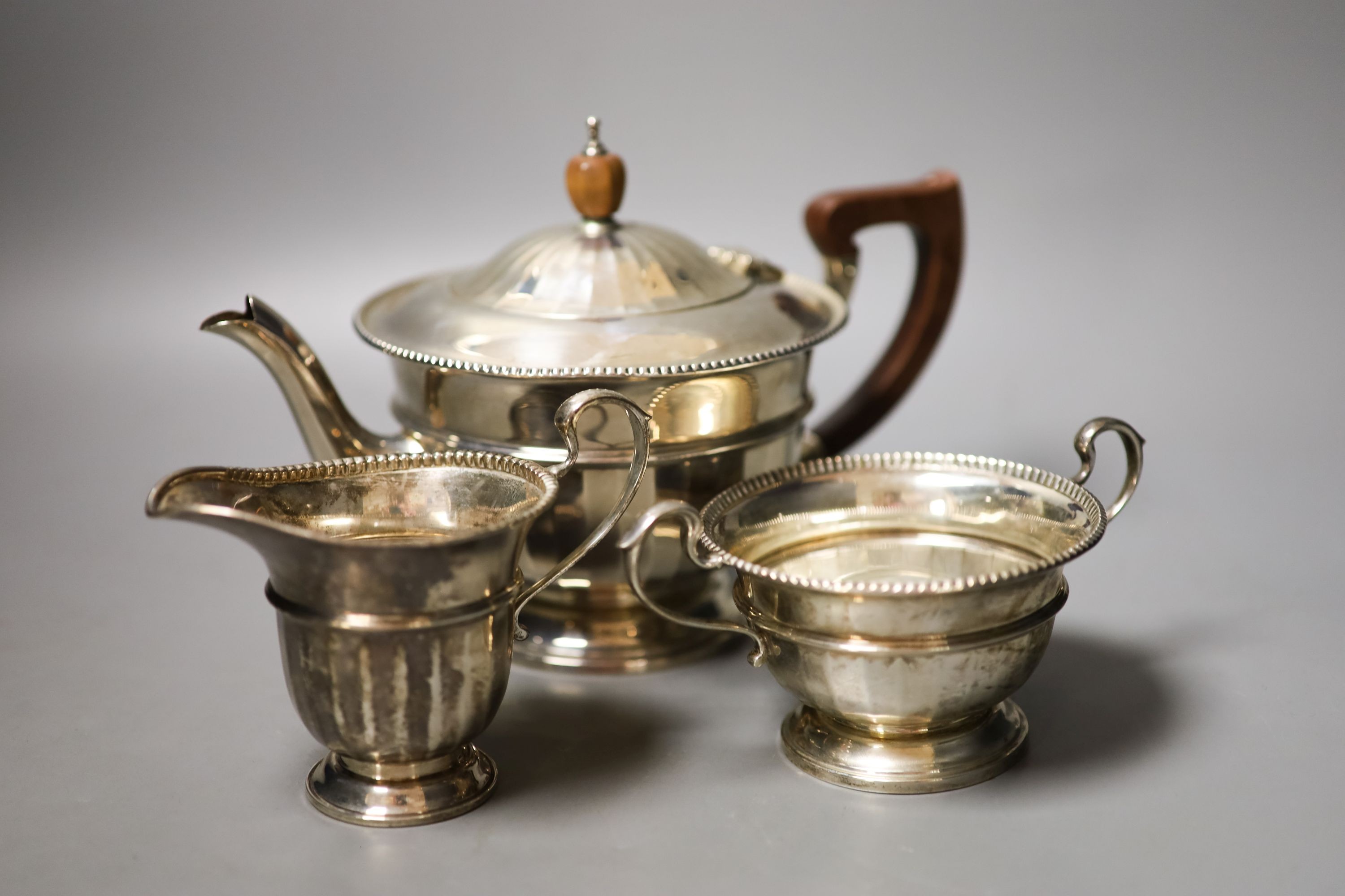 A George V silver circular three piece tea set, Birmingham, 1931/2, gross weight 18.5oz.